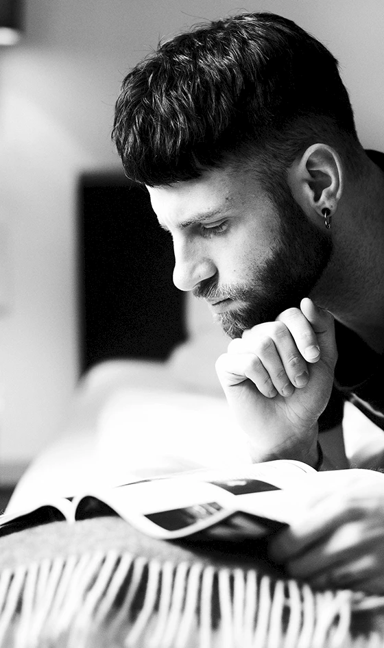 Eine Person liest auf dem Bett ein Magazin.