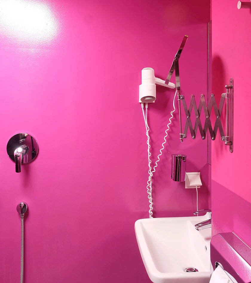 Ein Badezimmer mit pinken Wänden.