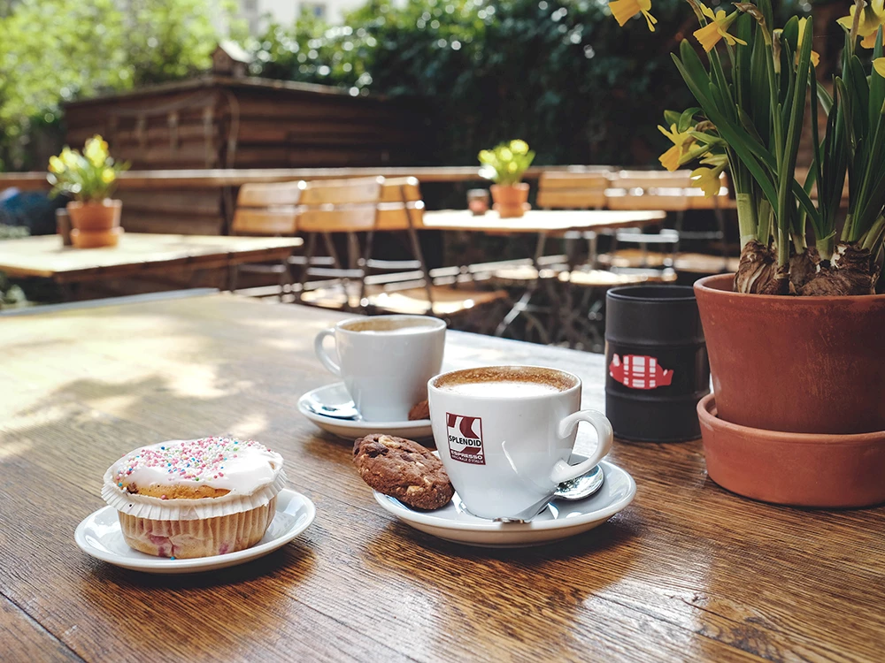 Ein Tisch mit zwei Kaffeetassen und einem Muffin.
