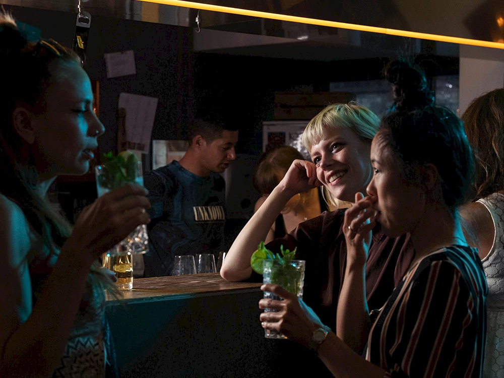 Eine Gruppe die an der Bar ist und was trinkt.